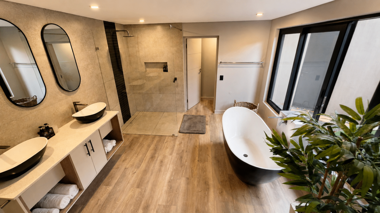 Spacious ensuite bathroom with walk-in rain shower and freestanding tub.