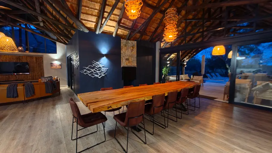 Dining table set for the evening, opening onto the patio and pool.
